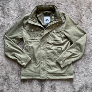 J Lindberg field jacka - Säljer min sprillans ny field jacka från j Lindberg med metal emblem på ärmen. Perfekt för vår vädret. Storlek M utan defekter. Mått finns på sista bild