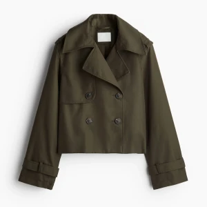 Olivgrön croppad trenchcoat - Säljer denna trendiga jacka från HM. Snygg olivgrön croppad trenchcoat med dubbelknäppning och klassisk krage. Jackan har långa ärmar. Perfekt för en trendig look! Använd bara några gånger. Inga tecken på användning. Stor i storleken. Använder oftast S. Skickar mera bilder om ni är intresserade!.