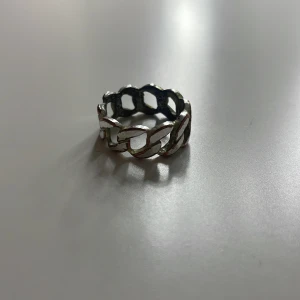 Silverfärgad ring med kedjedesign - Snygg och stilren ring i silverfärg med en unik kedjedesign. Perfekt för att ge en edgy touch till din outfit. Passar bra på både ring- och pekfingret.