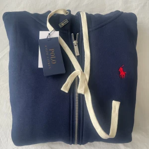 Ralph lauren zip hoodie - Stilren hoodie ifrån Ralph lauren i storlek L, sitter mer som M! Skick 10/10 aldrig använd. Hör av dig vid minsta fråga🤗