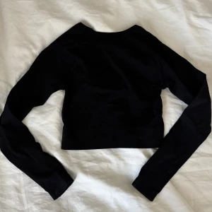 Tränings topp - Svart croppad tränings tröja med tajt passform och ribbat material. Använd några få gånger
