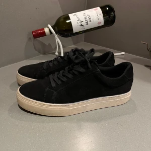 Svarta skor från Vagabond - Snygga svarta skor från Vagabond i mocka med vit sula. Mycket bra skick, nästan som nya men har en defekt med lite blått runt om på sulan som ni ser på bild 5. Nypris: 1400kr. Skriv gärna vi frågor!