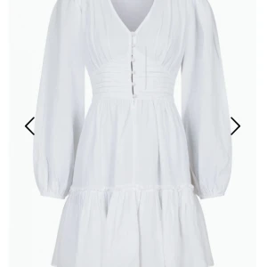 Vit klänning med knappar - Säljer en söt vit klänning med v-ringning och knappar framtill. Klänningen har långa ärmar och en volangdetalj vid kjolen. Perfekt för en somrig look! Använd 1 gång nypris 900 pris kan diskutera vid snabbaffär finns en fläck på den 