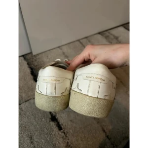 Vita sneakers från Saint Laurent - Snygga vita sneakers från Saint Laurent med stjärndetaljer på sidorna. Skorna har klassisk snörning och är tillverkade i Italien. Perfekta för en stilren look.