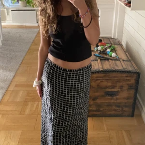 Lågmidjad långkjol💋 - Snygg svartvit rutig långkjol med ett klassiskt mönster. Perfekt för en stilren look. Kjolen har en bekväm passform och är lätt att matcha med olika toppar.