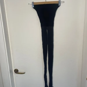 Svarta strumpbyxor kompression - Säljer ett par svarta strumpbyxor med kompression. De är tunna och genomskinliga, perfekta för att komplettera en outfit. Strumpbyxorna har en elastisk midja för bekväm passform. Litet hål fram, se foto. Annars aldrig använda.