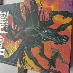 Harry Potter och Fenixorden - Säljer boken 'Harry Potter och Fenixorden'. Den har ett färgstarkt omslag med en illustration av en ryttare på en mystisk varelse. Perfekt för fans av magi och äventyr! Lite skada på ryggen