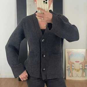 Mörkgrå ullkofta från H&M - Säljer en stilren mörkgrå kofta från H&M i ullblandning. Strl M, aldrig använd. Lappar kvar. Nypris: 1499kr.