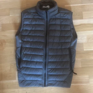 Grå dunväst från Stone Island - Säljer en snygg grå dunväst från Stone Island i storlek M. Perfekt till vår/höst. Skick 8/10 nypris: 5699kr. Pris kan diskuteras 