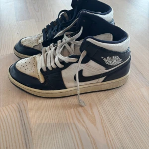 Nike Air Jordans blå/vita stl 43 - Säljer ett par välanvända slitna  klassiska Nike Air Jordans i blått och vitt. Har bytt skosnören till olika färger.  Skorna är en  hög modell med  logga på sidan. Perfekta för sneakerheads som älskar retrostil. Skorna är slitna/lädret trasigt upptill, skickar gärna närmare foton. Därav priset. Behöver lite kärlek och rengöring. 