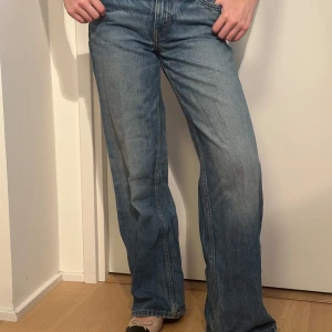 Blå jeans med bootcut - Snygga blå jeans med bootcut-stil och klassisk femficksdesign. De har en medel hög midja och en avslappnad passform. Perfekta för en casual look. Ungefär storlek 32-34. 