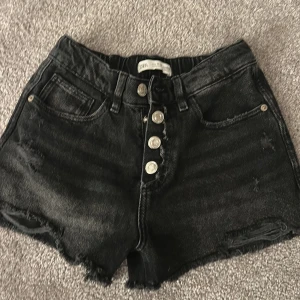 Svarta jeansshorts med knappar från Zara - Svarta jeansshorts från Zara  skulle säga att dem är mid waist