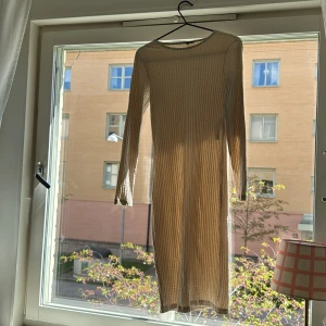 Beige ribbad långärmad klänning från Vera Moda - Säljer en beige ribbad klänning från Vera Moda i storlek XS. Klänningen har lång ärm, rund halsringning och är figurnära med stretchigt material. Perfekt för dig som gillar enkel och stilren design.