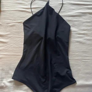 Svart body från H&M - Enkel och stilren svart body från H&M. Perfekt klassisk passform som passar de flesta stilar.