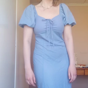 Ljusblå klänning - Supersöt ljusblå klänning med puffiga kortärmar och knyt framtill. Hjärtformad skurning, Storlek S ☺️