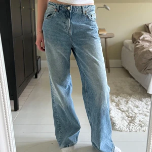 Blåa jeans från Monki - Säljer ett par blåa jeans från Monki i W27. Längden är jag osäker på men jag tror det är L34, jag är 175cm och de sitter perfekt i längden på mig. Jeansen är använda ett fåtal gånger och är är mycket fint skick!