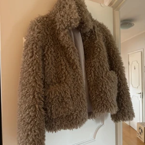 Beige/brun teddyjacka från Zara - Säljer en fluffig teddyjacka från Zara. Jackan har lång ärm, hög krage och två stora fickor framtill. 