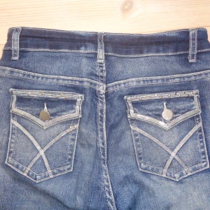 Blå jeans med broderade bakfickor - Bootcut jeans med detaljerade fickor, midjemått: 35, innerbenslängd: 75