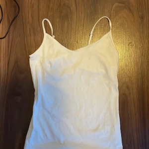 Linne  -  Säljer ett vitt linne från Lager 157 i storlek XS. Linnet har ställbara axelband och dubbelt tyg upptill. 