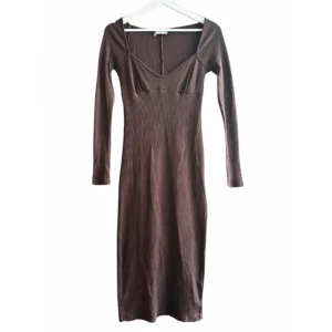 Brun långärmad ribbad klänning - Säljer en brun långärmad klänning med ribbad struktur. Klänningen har en smickrande passform och slits baktill. Perfekt för dig som gillar stilrena och enkla plagg.