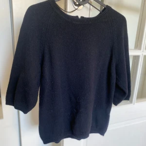 Mörkblå stickad tröja med trekvartsärm - Mysig mörkblå stickad tröja med rund halsringning och trekvartsärmar. Perfekt till jeans eller kjol för en enkel och stilren look. Snygg och enkel att matcha med det mesta.