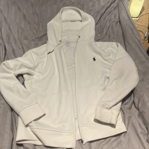 Vit hoodie med dragkedja från Polo Ralph Lauren - Vit Ralph Lauren zip hoodie  i 4/10 skick. Pris kan diskuteras. Passar M-L, ganska stor i storleken