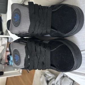 Svarta Adidas Campus sneakers med grå detaljer - Säljer ett par svarta Adidas Campus sneakers köpta tidigare då storleken inte satt rätt. Slutsålda typ överallt. Endast använda 1 gång. Buda gärna!
