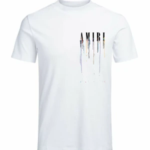 Vit AMIRI t-shirt med färgstänk - Vit t-shirt från AMIRI med snyggt tryck både fram och bak. Stora svarta bokstäver med färgstänk i blått, gult, rött och svart som rinner ner över tyget. Klassisk passform med rund hals. Perfekt för dig som gillar streetstyle och unika detaljer.