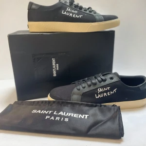 Svarta Saint Laurent sneakers 42-43 - Säljer skorna då de ej passa, de är oanvända.  Ganska trånga, det är storlek 43 men tror att 42 skulle passa även då de e lite trånga. Boxen är i lite dåligt skick men allt annat är bra. Syns på bilden hur boxen är. Snabb affär prioriteras. Skriv vid frågor. Kontakta innan köp.
