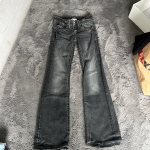 Svarta bootcut jeans Gina Tricot 146 - Snygga svarta jeans från Gina Tricot i storlek 146. Jeansen har bootcut-modell med utsvängda ben, klassisk femficksdesign och slitna detaljer för en cool look. Perfekta för dig som gillar en avslappnad men trendig stil.