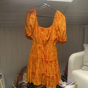 Orange kort klänning med puffärm - Superfin orange kort klänning med broderade blommor och puffiga korta ärmar. Använd två gånger från Zara. 