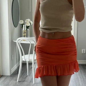 Orange volangkjol  - Superfin orange kjol med volangkant och rynkade detaljer på sidan. 🧡