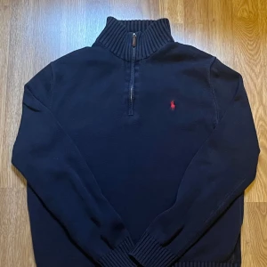 Mörkblå stickad tröja Polo Ralph Lauren - Den är ganska använd men fortfarande i jätte bra skick och inga täcken på användning. Fick den som present så tyvärr har inte kvitto men den är äkta! Buda på! Nypris 1500.