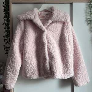 Ljusrosa Teddyjacka från Carin Wester - Mjuk teddyjacka i ljusrosa från Carin Wester. Jackan har bred krage, lång ärm, fluffig och lite oversized. Använd ett par gånger bara och inga defekter!💗