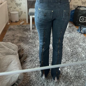 Mörkblå jeans med dragkedjor bak - Säljer ett par mörkblå jeans med en kedja på bak benen som man kan justera om man vill ha skinny jeans eller flared jeans, dom är från ( fashion b.p.c bonprix ) storleken har försvunnit på lappen men jag har vanligt vis w24, ett tips om ni inte är säkra fråga mig om midje måttet så fixar jag💕