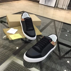 Burberry svarta sneakers med rutigt mönster - Snygga svarta sneakers från Burberry med klassiskt beige och svart rutigt mönster på hälen. Skorna har vita platta sulor, svarta snören och detaljer i skinn och textil. Perfekta för dig som vill ha en stilren men ändå unik look. Kvitto finns!!!