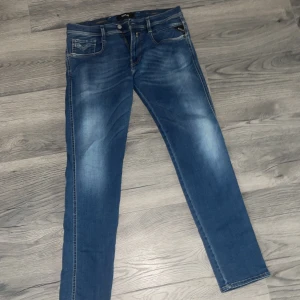 Blå skinny jeans från Replay - Snygga blå skinny jeans från Replay med klassisk femficksdesign och coola slitningar framtill. Jeansen har smal passform och normal midja, perfekta till sneakers eller boots. Materialet är stretchigt jeans för extra komfort.