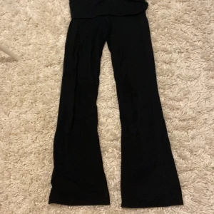 Svarta bootcut yogabyxor Gina Tricot - Svarta yoga byxor från Gina Tricot i stretchigt och mjukt material. Byxorna har en klassisk passform med utsvängda ben och midja som sitter bekvämt. Perfekta för en stilren och trendig look.