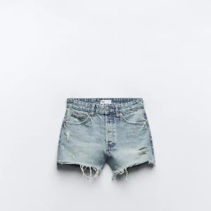 Högmidjade jeansshorts från Zara - Snygga högmidjade jeansshorts från Zara i ljusblå denim med slitna detaljer och fransig kant. Klassisk femficksmodell med knapp och dragkedja. Perfekta för en avslappnad och trendig look i sommar.