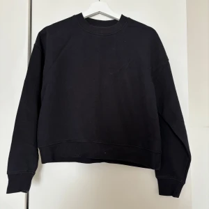 Svart sweatshirt från Lager 157, XS/S - En svart, basic sweatshirt från Lager 157 i storlek XS/S. Tröjan har rund hals, ribbade muddar och en loose fit. Perfekt för chill dagar eller när du vill ha en enkel och stilren look. Tillverkad i mjuk bomullsmix som känns skön mot huden.