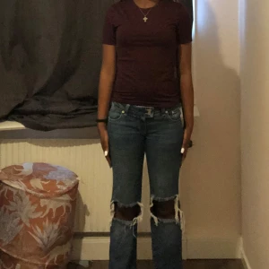 Mörkröd  t-shirt - En enkel och stilren mörkröd t-shirt med rund hals och korta ärmar. Modellen är figurnära och passar perfekt till jeans eller shorts. T-shirten är i mjukt bomullsmaterial och har en klassisk look utan tryck eller mönster.
