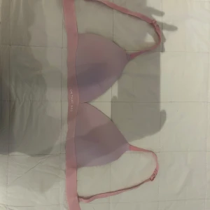 Rosa topp från On That Ass - Säljer en ljusrosa bandeau topp från On That Ass med justerbara axelband. Toppens material är mjukt och stretchigt, tillverkat av polyamid och elastan. Perfekt för dig som gillar en enkel och clean look med bekväm passform.