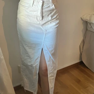 Vit jeanskjol med slits - Snygg vit lång jeanskjol med hög midja och en stor slits framtill. ”Sliten” look nertill. Använd några fåtal gånger 💕💕