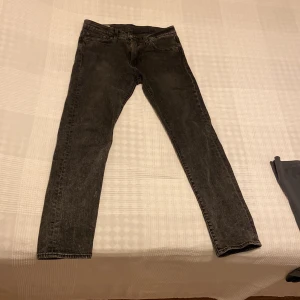 Levi's 502 svarta jeans W29 L32 - Säljer ett par svarta Levi's 502 jeans med klassisk femficksdesign och dragkedjegylf. Jeansen har en rak passform med något avsmalnande ben och är tillverkade i slitstarkt denim. Perfekta för dig som gillar en clean och tidlös look. Köpta för 1200 på Levis affären och har använts ganska ofta men bra omhand tagna