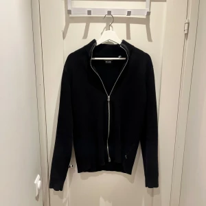 Svart tröja med dragkedja från Only & Sons - Snygg svart tröja från Only & Sons med dragkedja framtill. Perfekt för en stilren look. Tröjan har långa ärmar och en hög krage som kan bäras uppvikt eller nedvikt.