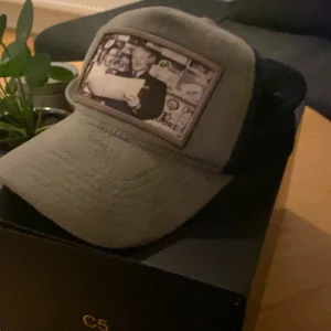 Grå blå keps från Maggiore - Snygg grå blå  keps från Maggiore med ett unikt tryck framtill. Perfekt för en avslappnad stil. Kommer i en exklusiv förpackning