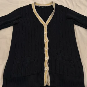 Ralph Lauren kabelstickad kofta - Säljer en snygg svart kofta från Ralph Lauren, den är extremt snygg o ger mycket komplimanger. 100% bomull, kabelstickad. Skriv för fler bilder. Knappen längst ner lite trasig men inget som påverkar användning o märks inte. passar XS 