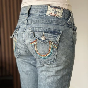 True religion jeans - Lågmidjade bootcut jeans från true religion. Snygg design. Bra skick, se bild. Mått: Innerbenslängd: 85cm   Midjemått rakt över: 37cm Modellen är 166cm lång. Fler bilder finns. Skriv gärna ifall du har några frågor! 💗 OBS se lagningar längst ner vid byxbenets baksida, även stor i storleken 