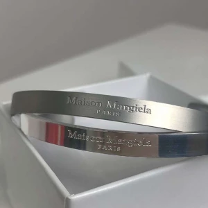 Silverfärgat armband från Maison Margiela - Maison margiela armband, liten repa annars bra skick. Skriv om frågor eller funderingar 