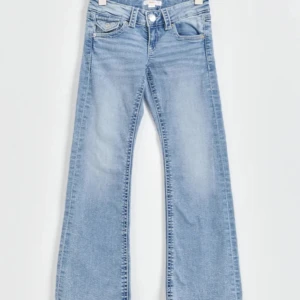 Blå bootcut jeans - Snygga blå bootcut jeans med klassisk femficksdesign och knappgylf. Perfekta för en avslappnad stil med en touch av retro.  Byxorna är aldrig använda.